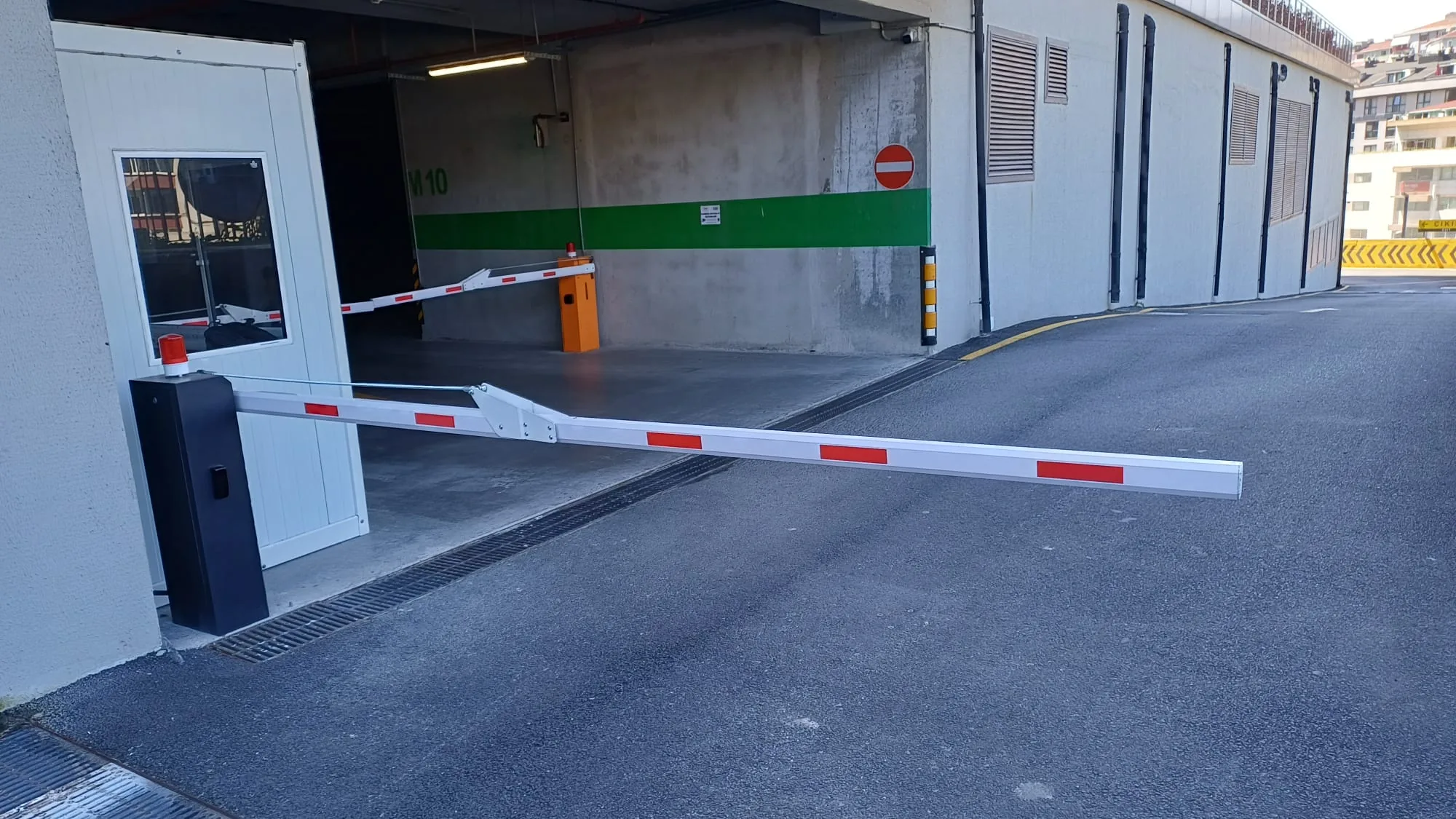 Kapalı otopark girişinde güvenlik kulübesi yanı kollu bariyer