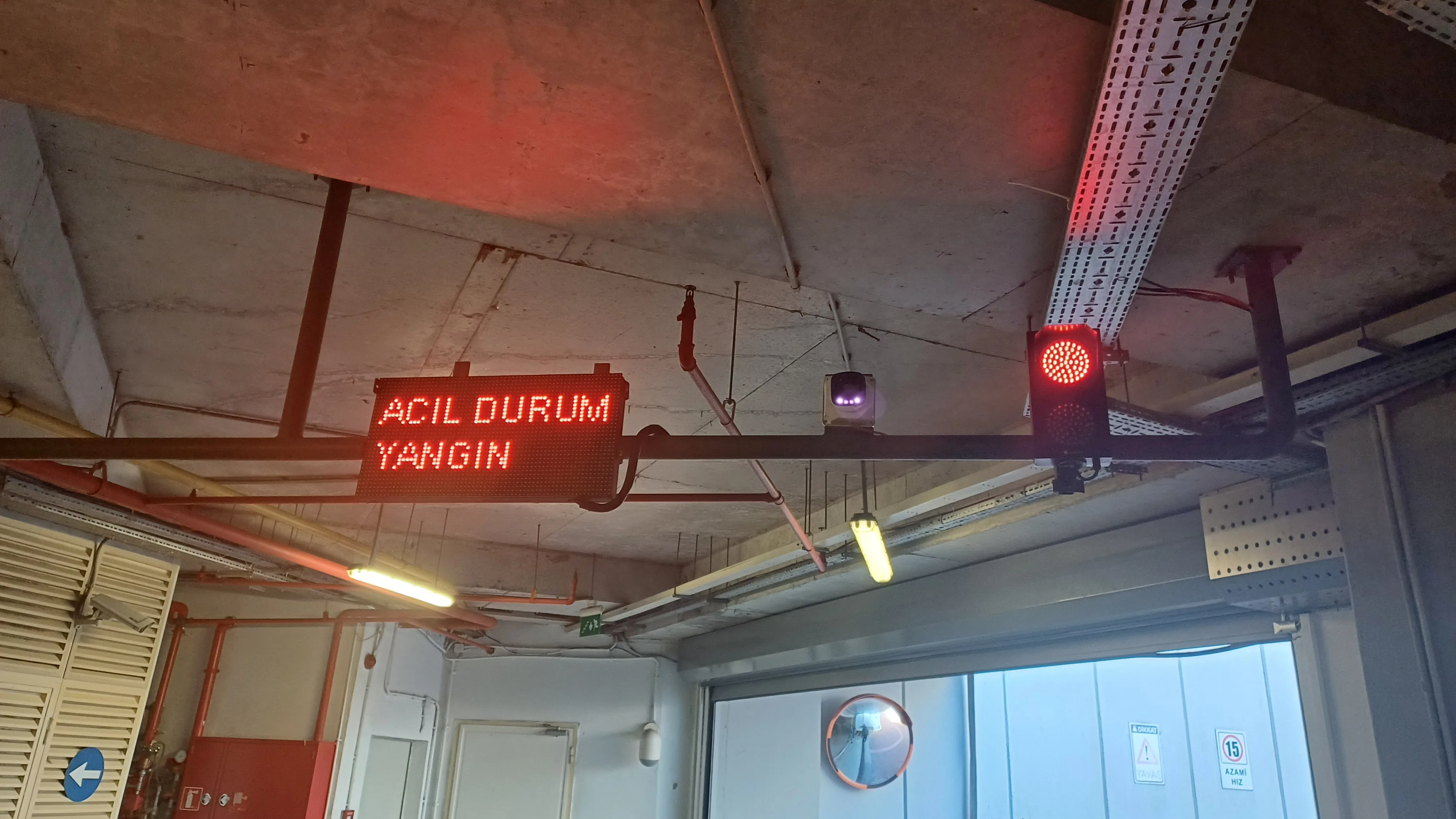 Kapalı otopark tavanında ACİL DURUM YANGIN LED ekranı ve kırmızı ışık