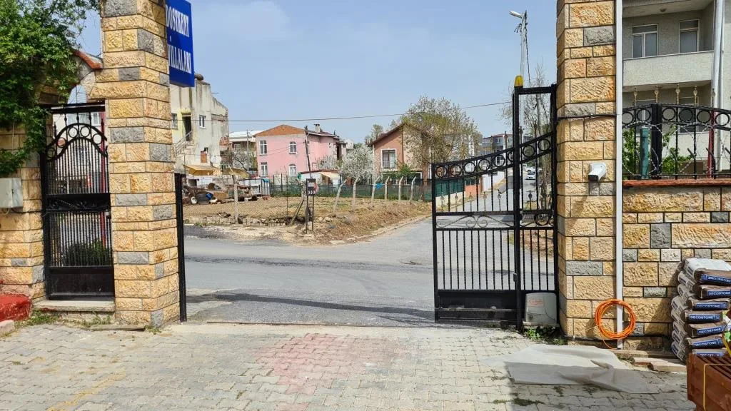 Site girişi taş sütunlu demir kapı